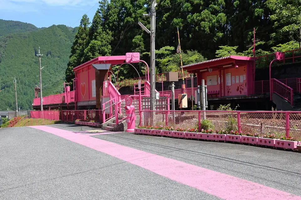 ピンク色の駅舎とホームが特徴の恋山形駅
