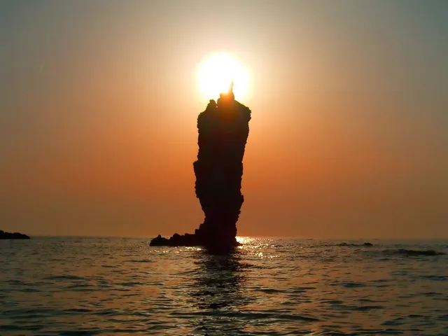 夕日が先端に重なるローソク島
